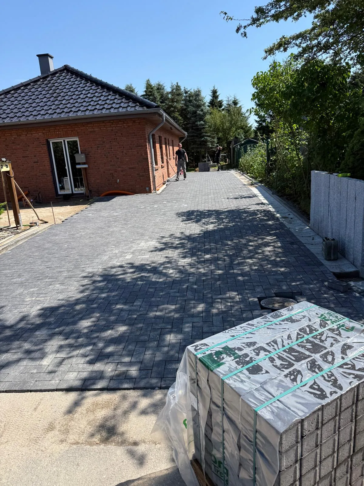 Fertiggestellte gepflasterte Zufahrt im Sonnenlicht