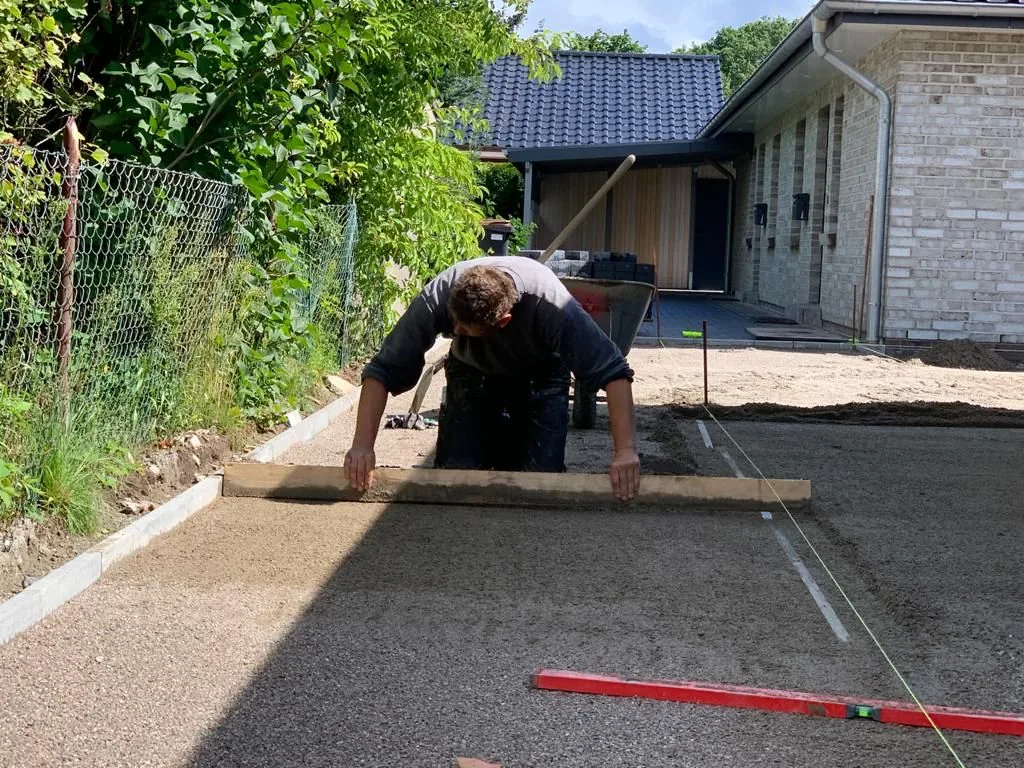 Mitarbeiter beim Vorbereiten einer Pflasterfläche